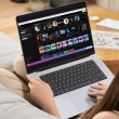 Une jeune femme dans son canapé écoutant Spotify depuis son PC portable